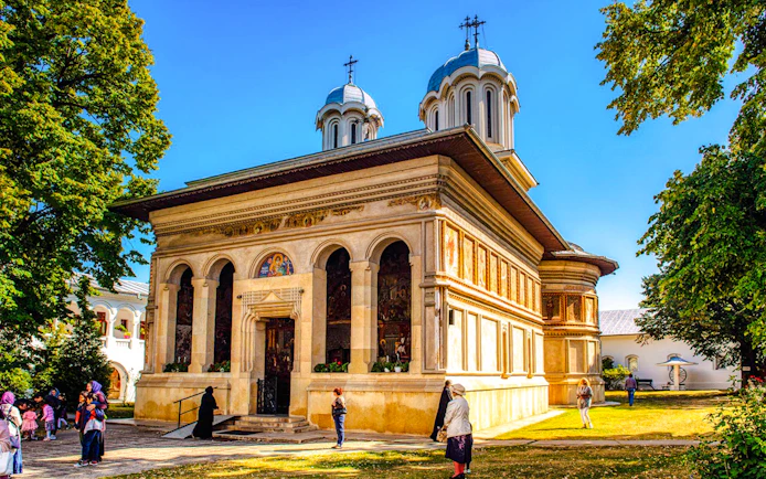 Snagov Monastery in Romania with visitors exploring the historic church and grounds.