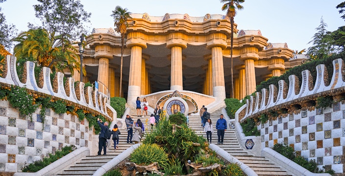 Park Güell entrance with mosaic tiles and columns in Barcelona.