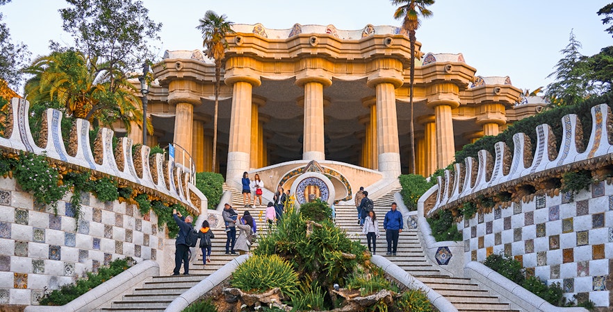 Park Güell entrance with mosaic tiles and columns in Barcelona.