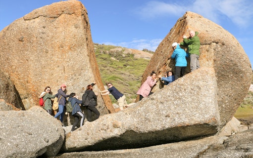 Group exploring rock formations at Wilsons Promontory National Park during a day tour from Melbourne.