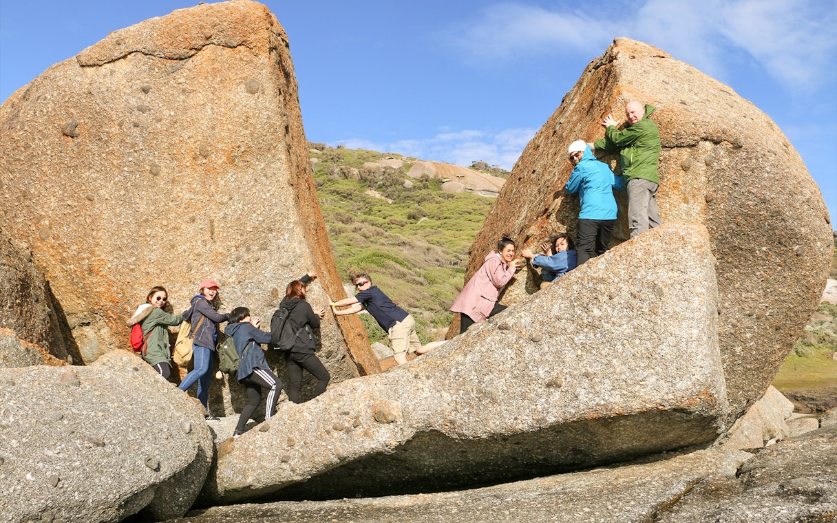 Group exploring rock formations at Wilsons Promontory National Park during a day tour from Melbourne.