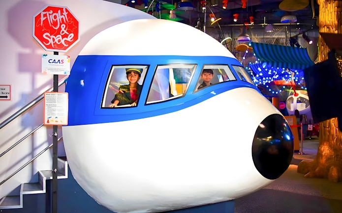 Children in a flight simulator at KidsSTOP Singapore.