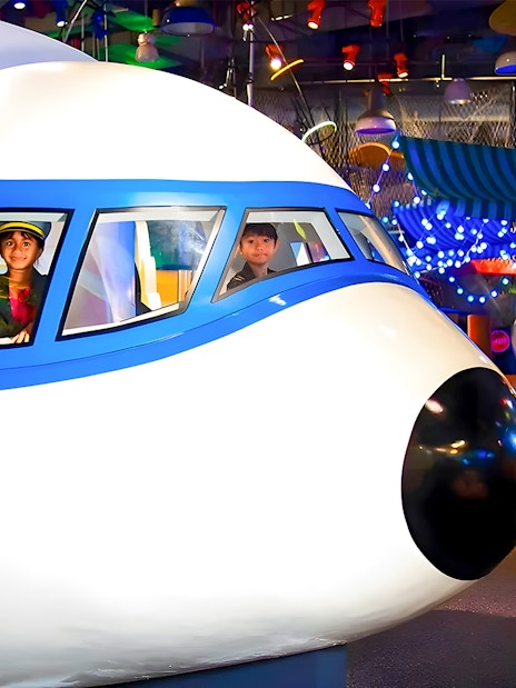 Children in a flight simulator at KidsSTOP Singapore.