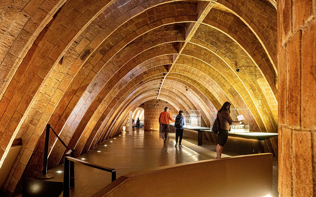 Casa Mila attic with visitors exploring Gaudi's architectural arches in Barcelona.