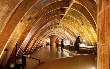 Casa Mila attic with visitors exploring Gaudi's architectural arches in Barcelona.