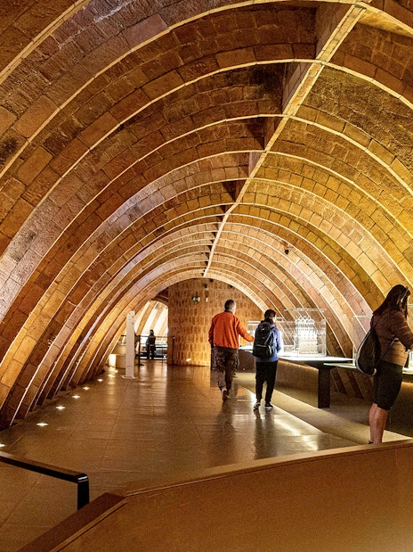 Casa Mila attic with visitors exploring Gaudi's architectural arches in Barcelona.