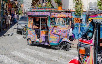 Colorful motochiva driving on a cobblestone street in Guatapé, Antioquia, Colombia.
