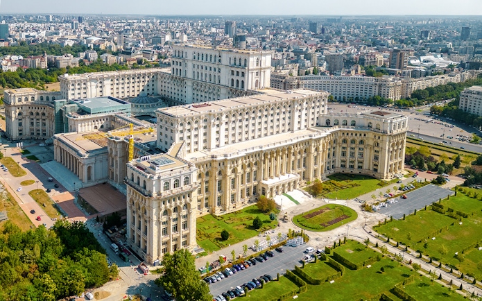 Aerial view of the Palace of Parliament in Bucharest, Romania, showcasing its grand architecture.