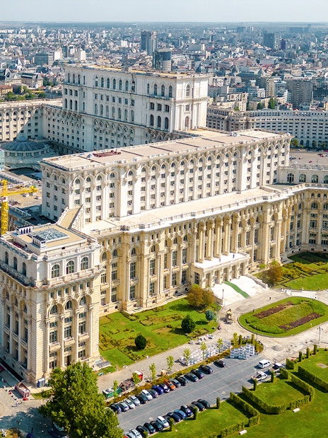 Aerial view of the Palace of Parliament in Bucharest, Romania, showcasing its grand architecture.