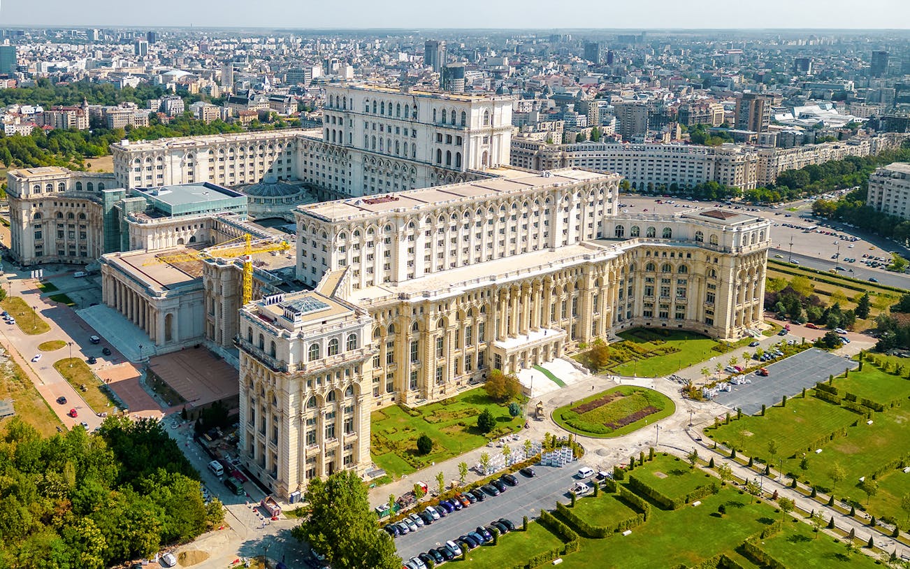 Aerial view of the Palace of Parliament in Bucharest, Romania, showcasing its grand architecture.