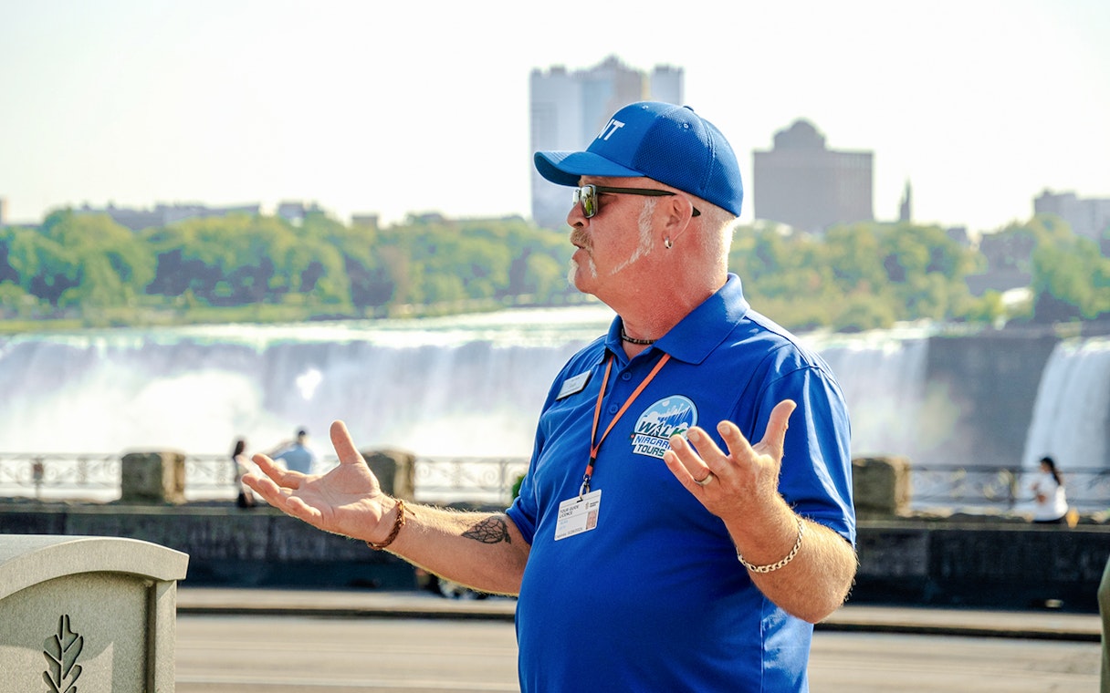Tour guide speaking with Niagara Falls, Canada in the background.