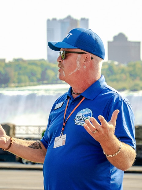 Tour guide speaking with Niagara Falls, Canada in the background.
