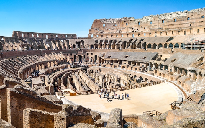 Visitors exploring the ancient Colosseum arena in Rome, Italy.