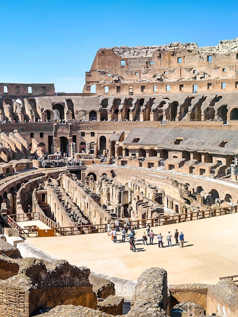 Visitors exploring the ancient Colosseum arena in Rome, Italy.