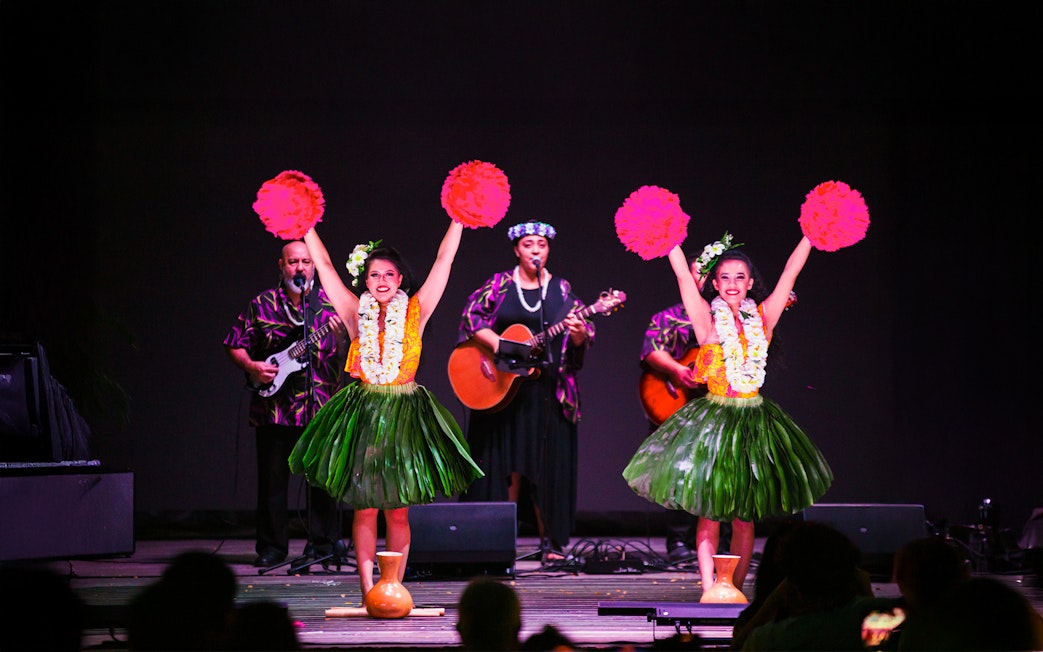 Performers at a traditional Hawaiian luau with musicians and hula dancers at Moana Luau, Hawaii.