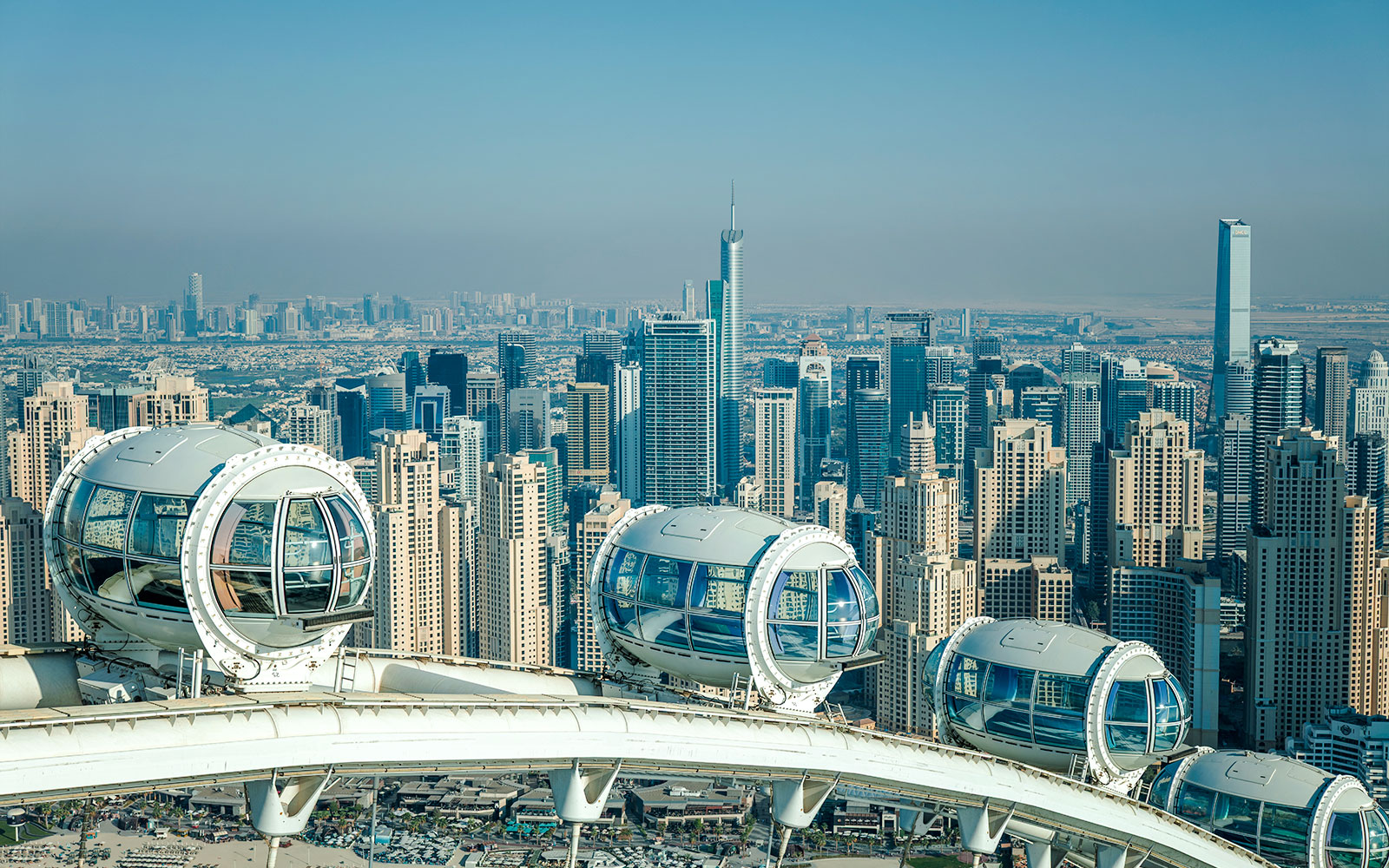 Ain Dubai pods overlooking Dubai skyline with skyscrapers in the background.