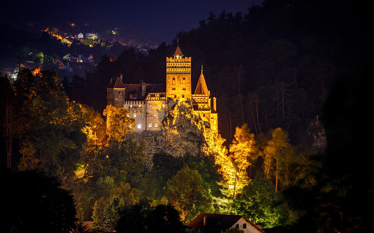 Dracula's Castle illuminated at night during Halloween tour in Transylvania.