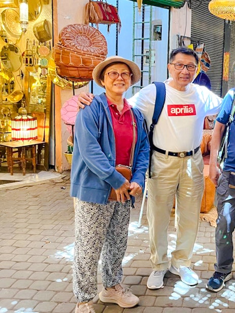 Tourists with guide exploring a lantern shop in Marrakesh souk, Morocco.