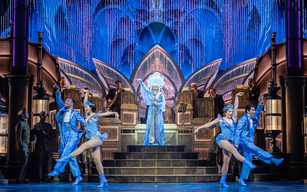 Performers in blue costumes dance on stage during The Great Gatsby Musical.