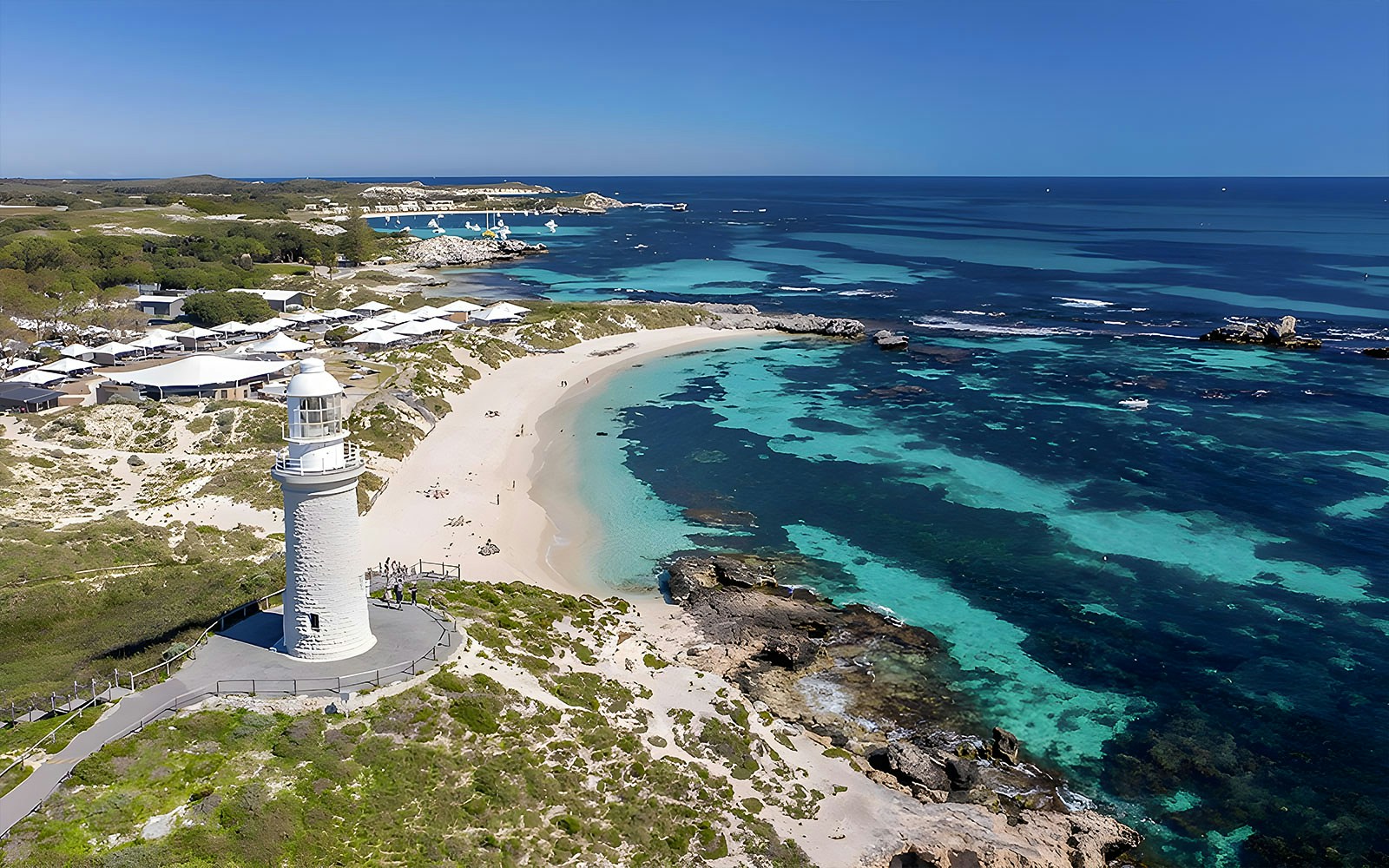 Rottnest Island coastline with lighthouse and turquoise waters, view from above.
