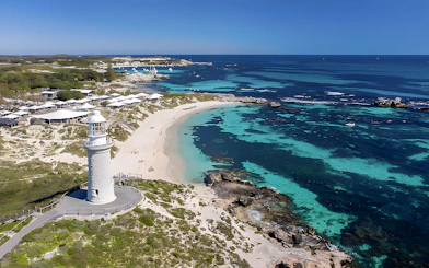 Rottnest Island coastline with lighthouse and turquoise waters, view from above.