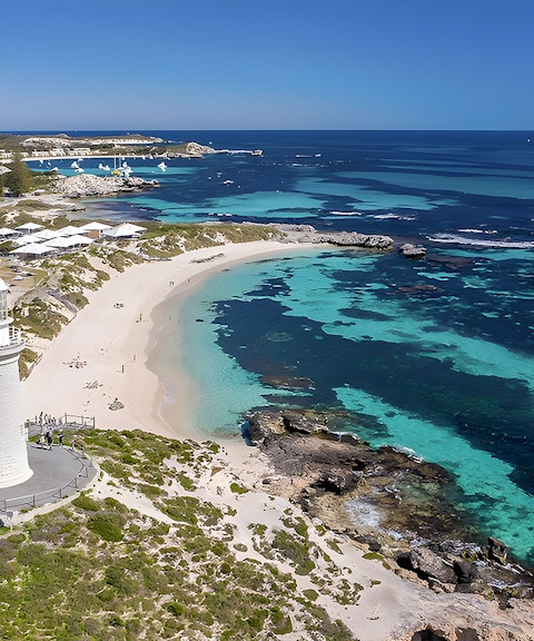 Rottnest Island coastline with lighthouse and turquoise waters, view from above.