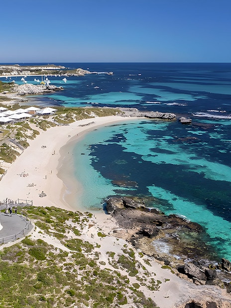 Rottnest Island coastline with lighthouse and turquoise waters, view from above.