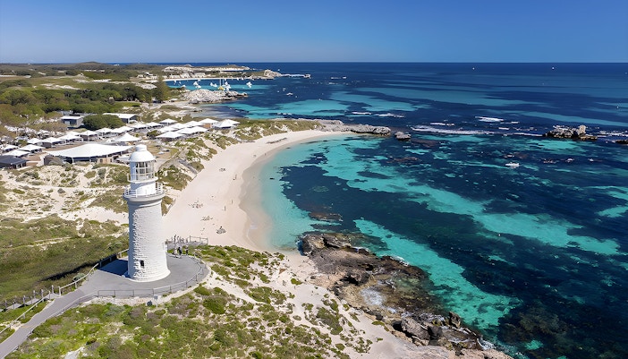 Rottnest Island coastline with lighthouse and turquoise waters, view from above.