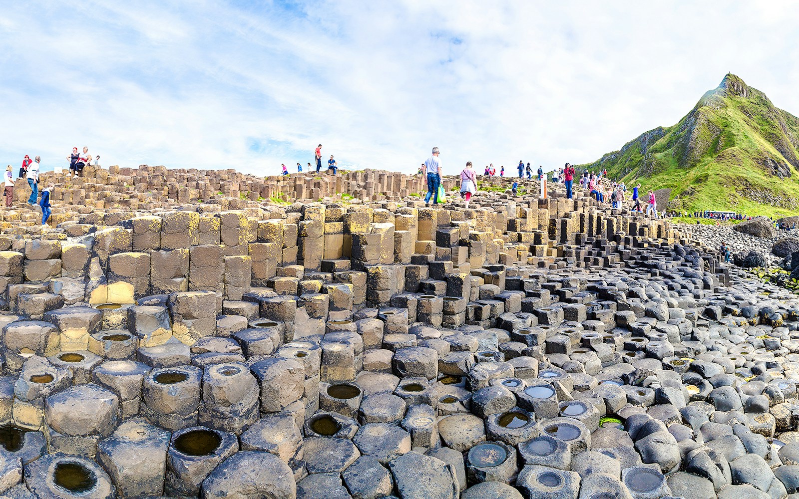 Visitors exploring basalt columns at Giant's Causeway, Northern Ireland.