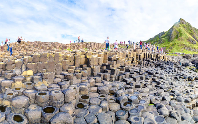 Visitors exploring basalt columns at Giant's Causeway, Northern Ireland.
