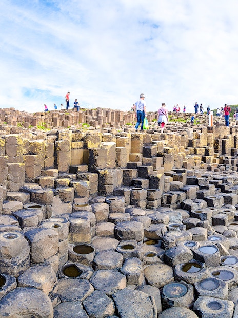 Visitors exploring basalt columns at Giant's Causeway, Northern Ireland.