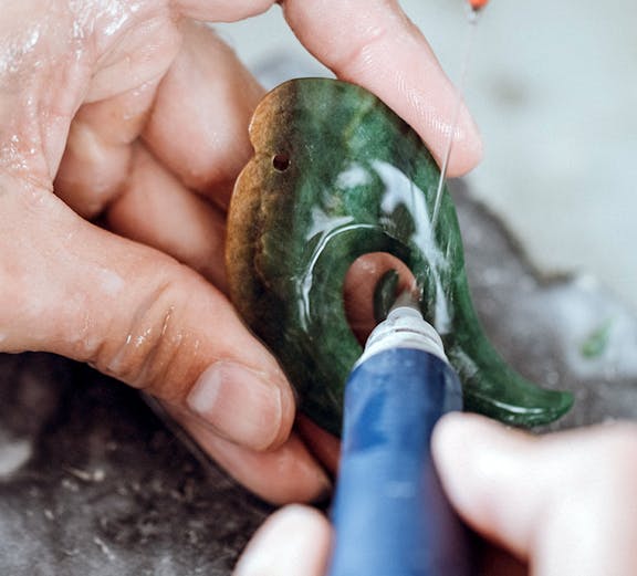 Carving jade pendant in Rotorua workshop.