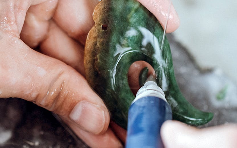 Carving jade pendant in Rotorua workshop.
