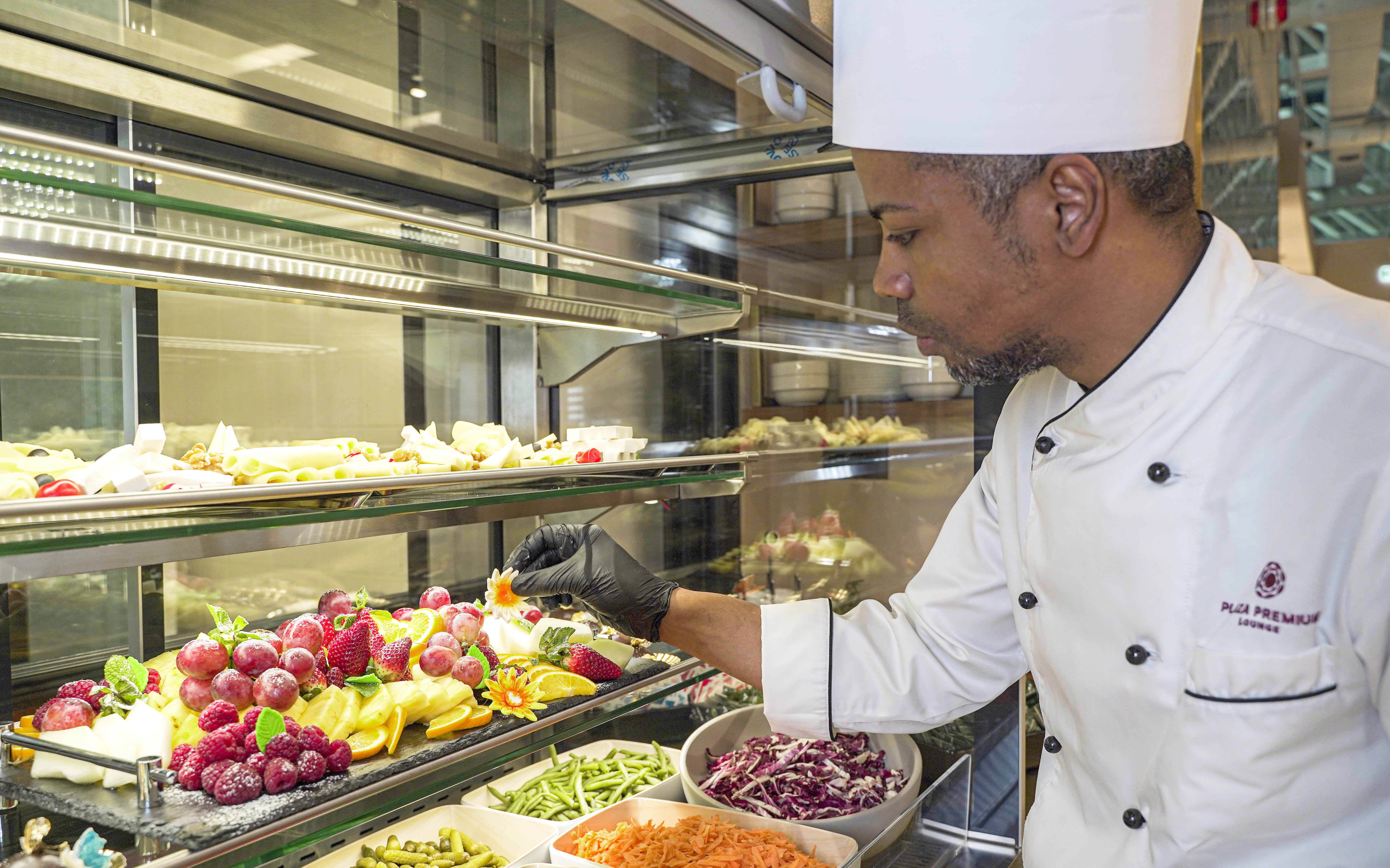 Chef arranging fruit display at Plaza Premium First Lounge, Rome Fiumicino Airport, Terminal 1.