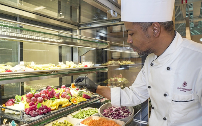 Chef arranging fruit display at Plaza Premium First Lounge, Rome Fiumicino Airport, Terminal 1.