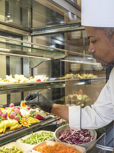 Chef arranging fruit display at Plaza Premium First Lounge, Rome Fiumicino Airport, Terminal 1.