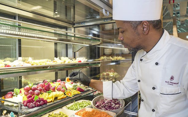 Chef arranging fruit display at Plaza Premium First Lounge, Rome Fiumicino Airport, Terminal 1.