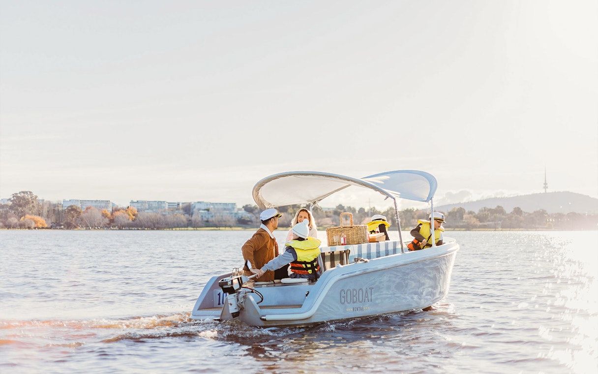 Electric picnic boat on Lake Burley Griffin, Canberra, with passengers enjoying a ride.