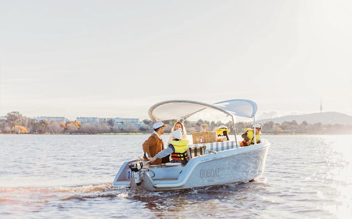 Electric picnic boat on Lake Burley Griffin, Canberra, with passengers enjoying a ride.