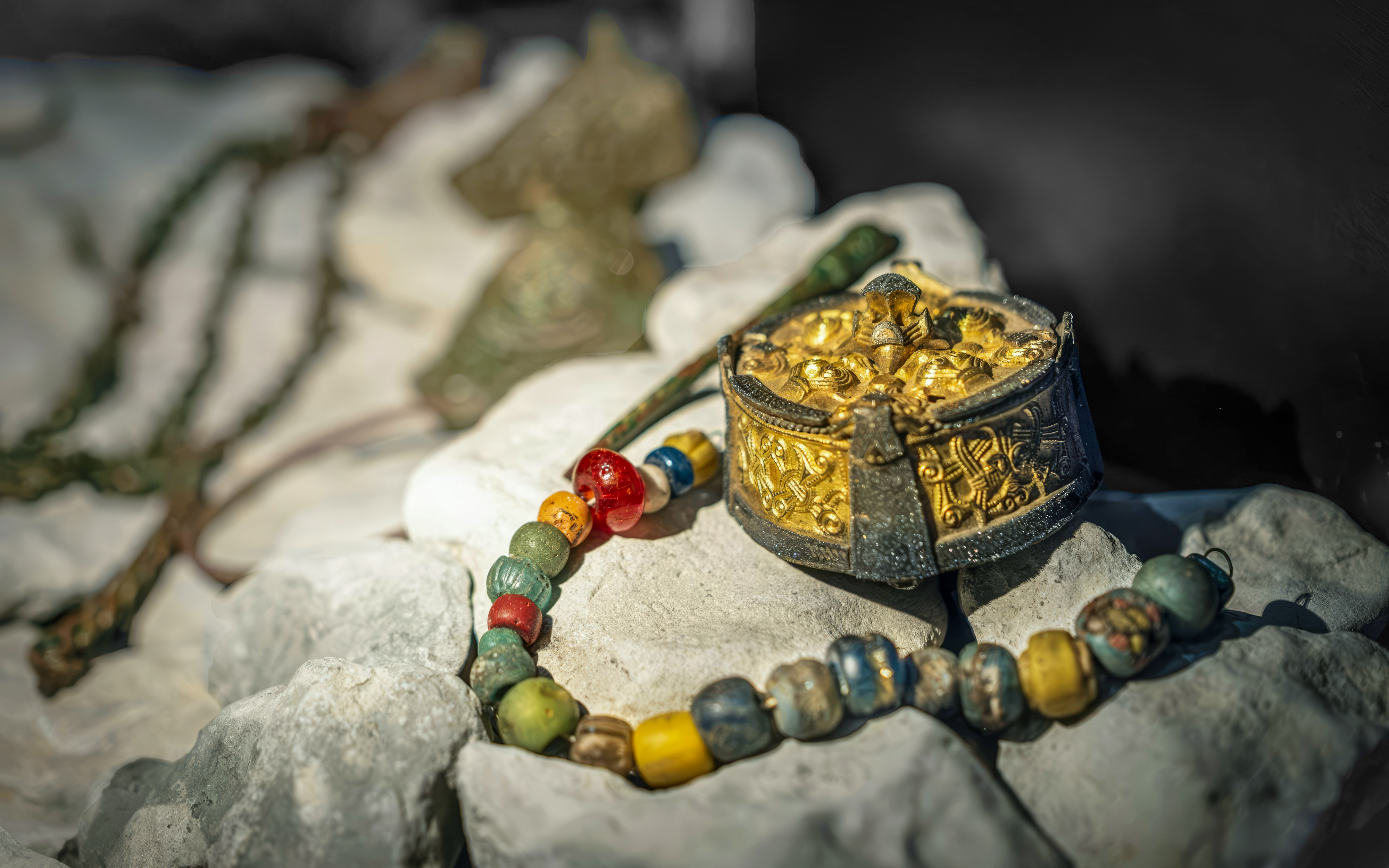 Viking artifacts including a gold brooch and beaded necklace at a museum in Stockholm, Sweden.