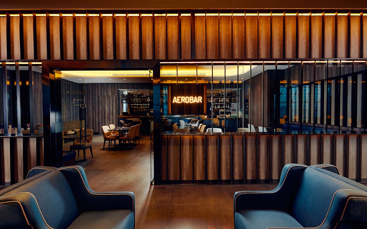 Plaza Premium Lounge seating area with Aerobar at Dubai International Airport.