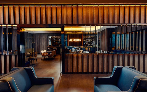 Plaza Premium Lounge seating area with Aerobar at Dubai International Airport.