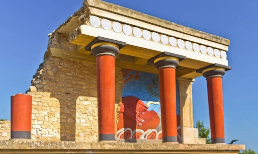 Knossos Palace ruins with tourists exploring, Heraklion Archaeological Museum audio guide experience.