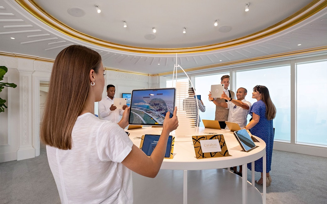 Guests exploring digital displays during Inside Burj Al Arab Tour at UMA Lounge.