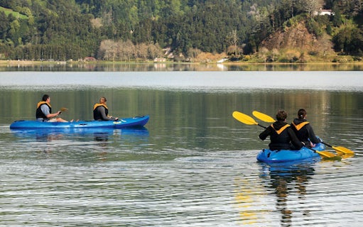 People kayaking on a lake surrounded by lush greenery in Furnas.