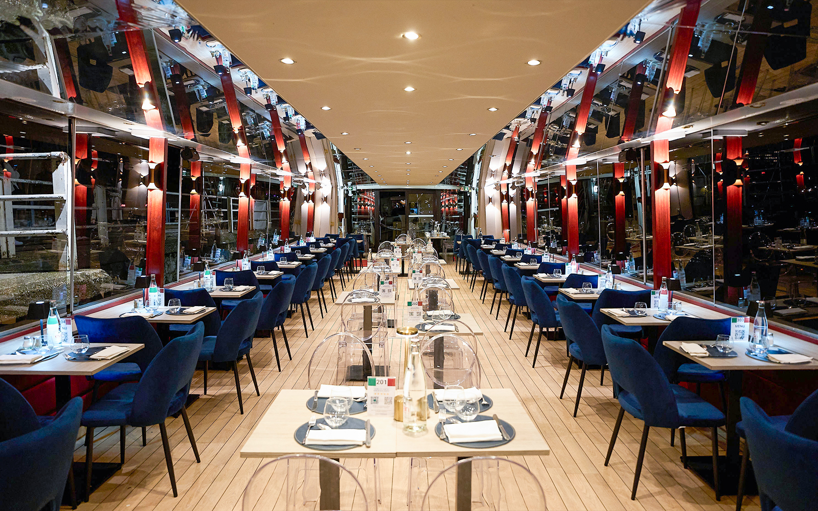 Seine River dinner cruise interior with tables set for an Italian menu experience.