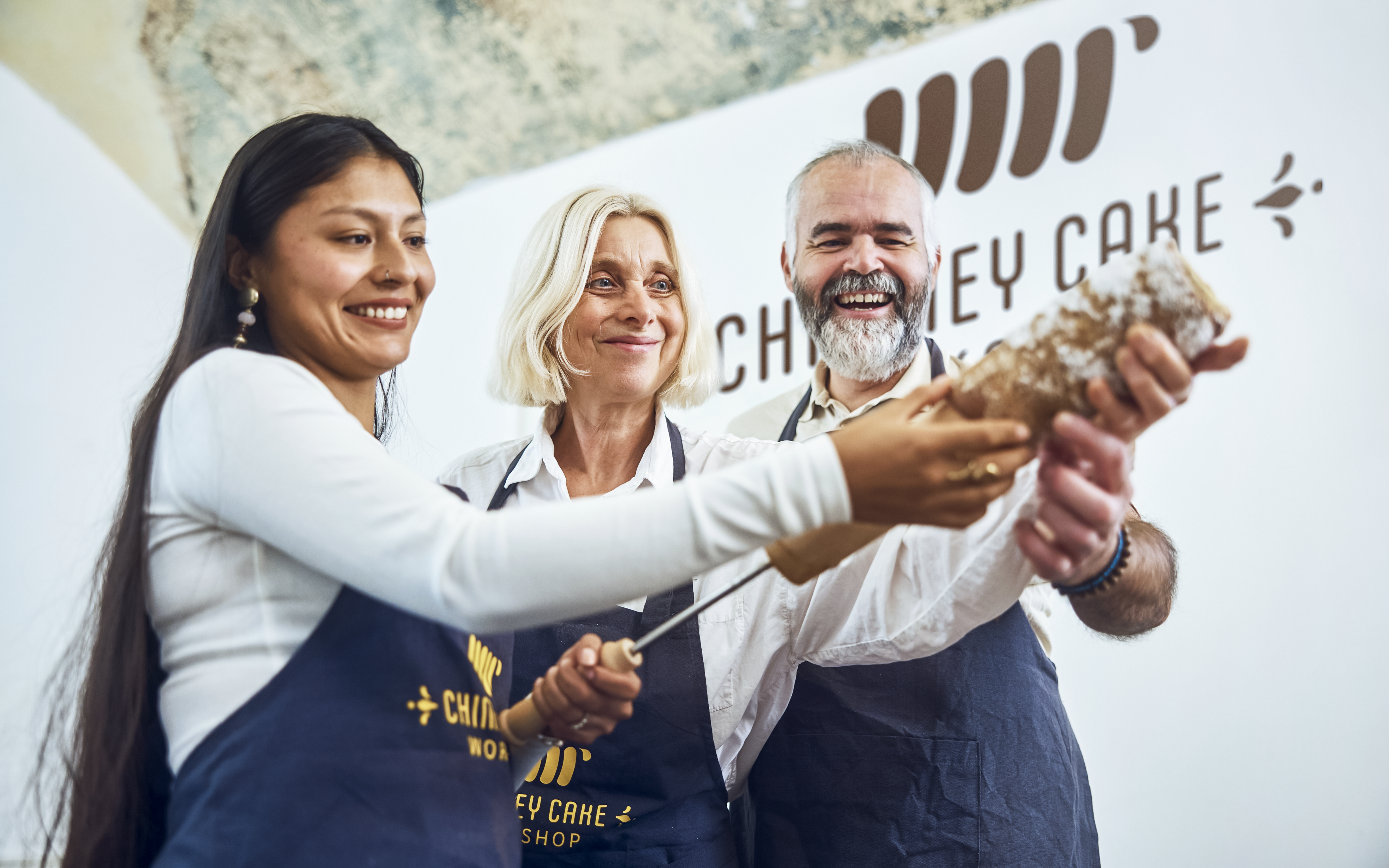 Participants making chimney cake at a Budapest workshop.