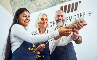Participants making chimney cake at a Budapest workshop.