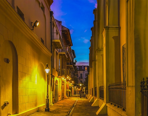Pirates Alley in the French Quarter, New Orleans, featuring historic architecture and vibrant street life.