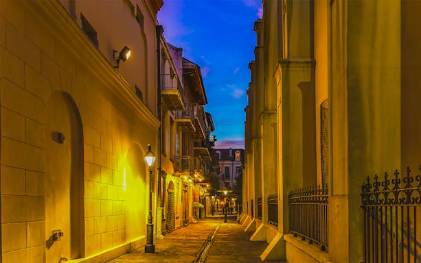 Pirates Alley in the French Quarter, New Orleans, featuring historic architecture and vibrant street life.